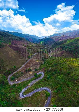 Top View Of Green Field Mountain Forest And Winding Curve Road Transportation For Background, Scenic