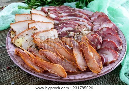 Big Meat Set. Homemade Smoked Pork-beef Sausage, Salted Bacon, Basturma Chopped Slices On A Wooden B