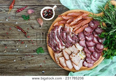 Big Meat Set. Homemade Smoked Pork-beef Sausage, Salted Bacon, Basturma Chopped Slices On A Wooden B