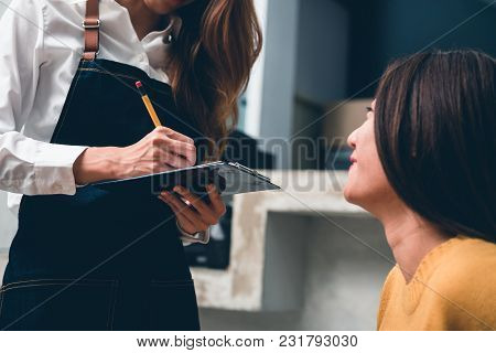 Close Up Of Young Asian Female Coffee Shop Owner Taking The Order From Her Client With A Warm Welcom