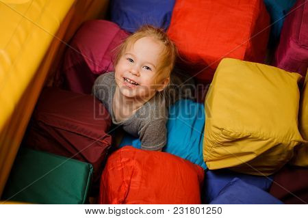 Cute Little Smiling Girl Playing Among The Big Tissular Multi Colored Cubes In The Playing Room