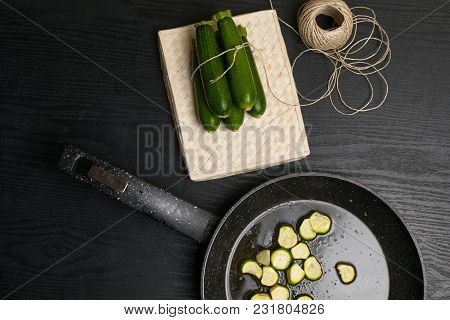 Cooked Vegetarian Food. Fried With Olive Oil Sliced Zucchini On Pan On A Rough Wood. And Raw Organic