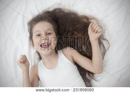 Cute Smiling Little Girl Woke Up In White Bed. Morning In Wekeend. Flat Lay.