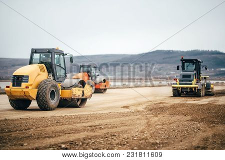 Vibratory Soil Compactors On Highway Construction Site. Industrial Roadworks With Heavy-duty Machine