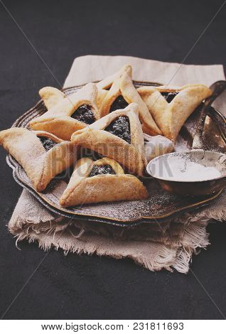 Hamantaschen Cookies With Poppy Seed And Risins And Icing Sugar On A Plate, Cooked For Jewish Festiv