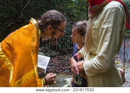 KOH CHANG, THAILAND - MAR 9, 2018: Orthodox priest during sacrament of spiritual birth - Baptism. There are currently 10 Orthodox parishes in Thailand, Orthodoxy is practiced by 0.002% of population.