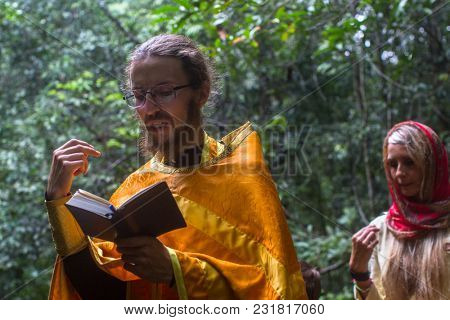 KOH CHANG, THAILAND - MAR 9, 2018: Orthodox priest during sacrament of spiritual birth - Baptism. There are currently 10 Orthodox parishes in Thailand, Orthodoxy is practiced by 0.002% of population.