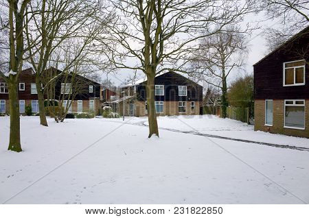 Bracknell, England - March 19, 2018: Modern Semi-detached Houses And Bare Winter Trees Covered In Sn