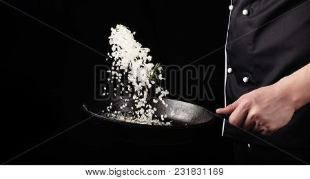 Cooking Roasted Aromatic Salt In A Pan By Chef Hand. Horizontal Photo View. Dark Black Background Wi