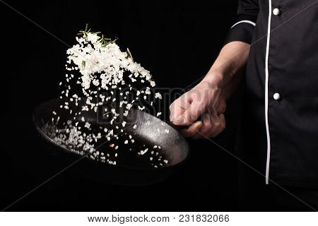 Cooking Roasted Aromatic Salt In A Pan By Chef Hand. Horizontal Photo View. Dark Black Background Wi