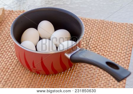 A Few Boiled Eggs In A Saucepan On Table