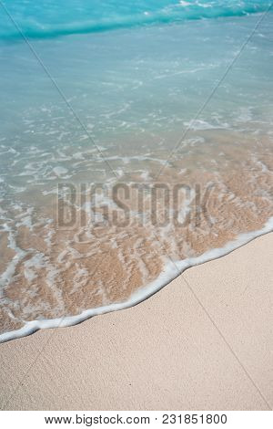 Blue Transparent Ocean Wave Rolling To Sandy Beach With Azure Water. White Wave Foam In Front.