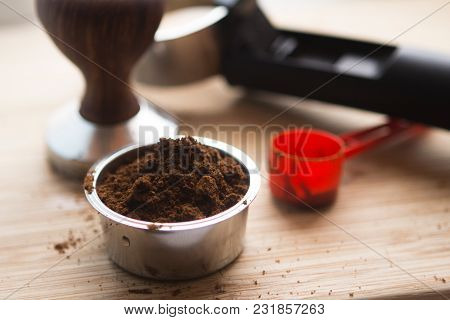 Coffee Tamper With Coffee In Filter Basket And Filter Holder On A Wooden Board For Coffee Scrub