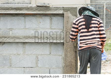 Construction Workers Masons Are Building The Wall From Concrete Blocks.
