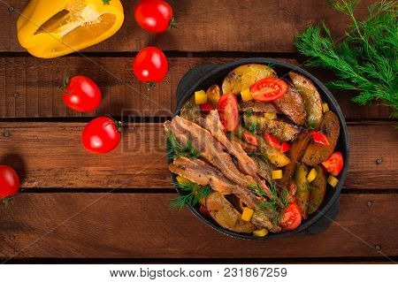 Fried Potatoes With Bacon And Fresh Tomatoes In The Frying Pan. Wooden Rustic Background. Top View.