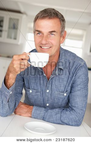 Midden leeftijd man met koffie thuis