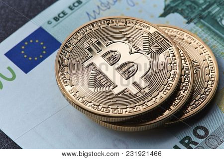 Stack of gold coins bitcoin stack on a euro bill