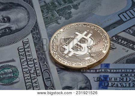 One gold coin in the background of dollar bills