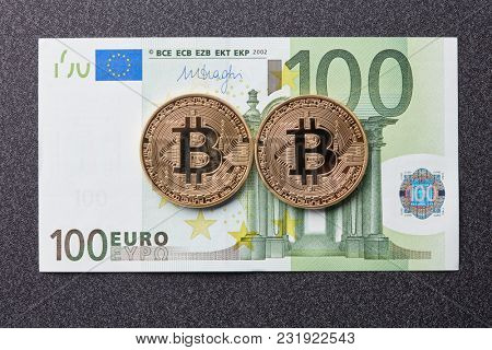 Gold coins bitcoin and one hundred euro banknote on a dark background