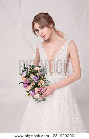 Beautiful Woman Holding A Bouquet Of Flowers Wearing In Luxurious Wedding Dress Isolated On Backgrou