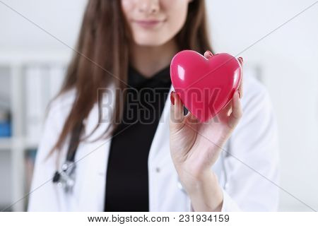 Female Medicine Doctor Hands Holding And Covering Red Toy Heart Closeup. Cardio Therapeutist Student