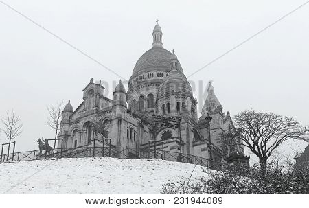 The Basilica Sacre Coeur Covered With Snow. It Is A Roman Catholic Church Located At The Summet Of T