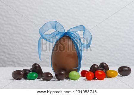 Easter Chocolate Egg With Lots Of Chocolate Candies In Decoration