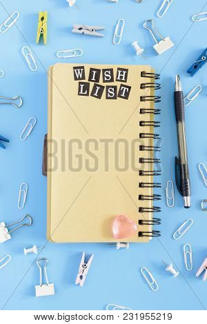 In The Center Lies An Open Notebook On Springs With Brown Pages. Stationery In Disorder On A Blue Ba