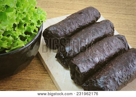 Japanese Cuisine, Traditional Unsliced Japanese Rice Maki Sushi Roll With Nori Seaweed On Cutting Bo