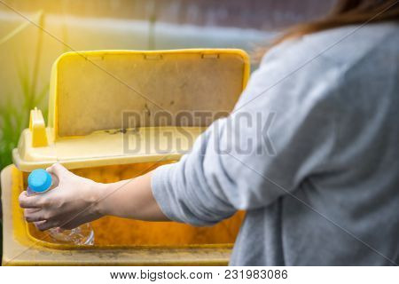 Close Up Hand Woman Put Empty Drinking Water Bottle In Separate Trash. Disposal Garbage Management E