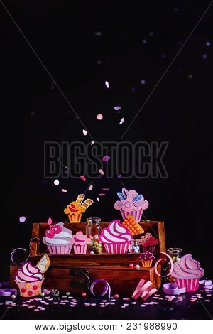 Celebration Concept. Cupcakes Collection On A Wooden Shelf With Flying Confetti And Sprinkles. Color