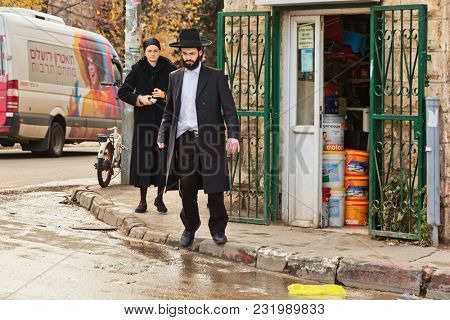 JERUSALEM, ISRAEL - DECEMBER 29, 2016: The Orthodox Jewish man crosses the road near to a small shop at the jewish quarter in Jerusalem.