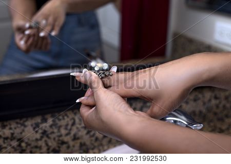 Pretty Black Female Getting Ready In Front Of A Bathroom Mirror Putting On A Ring And Jewelry.  She 