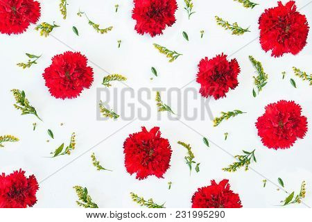 Floral Pattern Made Of Red Carnations, Green Leaves, Branches On White Background. Flat Lay, Top Vie