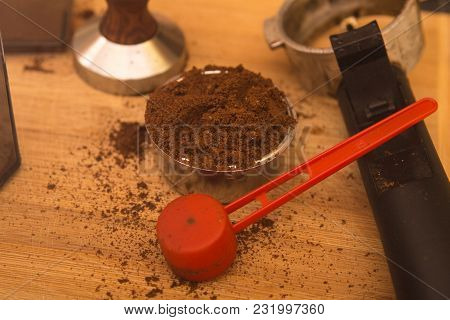 Coffee Tamper With Coffee In Filter Basket And Filter Holder On A Board