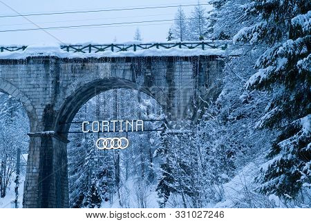 Cortina D Ampezzo, Italy - February 4 2019: Illuminated Cortina Sign With Audi Ring Logo On The Viad