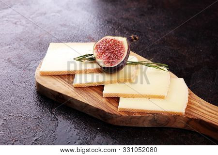 Raclette Cheese Sliced. Very Delicious Swiss Raclette On Rustic Background
