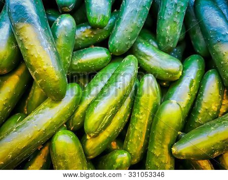 Pile Of Fresh Cucumbers Top View, Green Background.