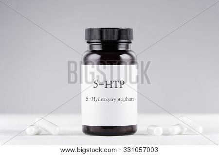 Nutritional Supplement 5-htp Hydroxytryptophan, Bottle And Capsules On Gray