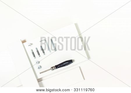 Tools For Assembly Of Flat Packed Furniture On White Background. White Diy Funiture Parts With A Scr
