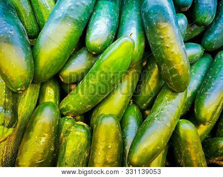 Pile Of Fresh Cucumbers Top View, Green Background.