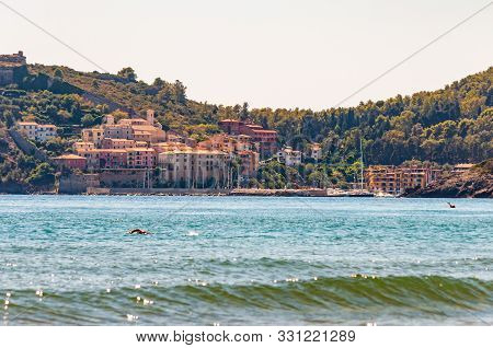 Man Swimming In The Sea With The Landscape Cityscape View Of The Poggio Pertuso In The Front Of The 