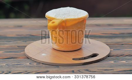 A Cup Of Flour Is On The Table.