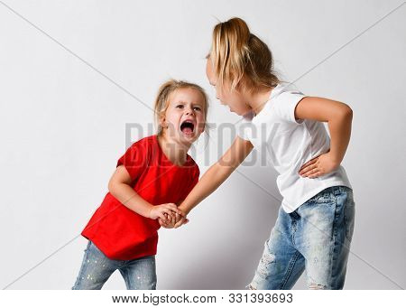 Two Girls Friends, Sisters In Jeans And T-shirts Are Fighting, Crying, Yelling, Argue, Hurt Each Oth