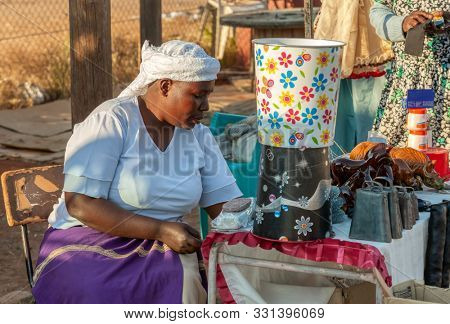 African street vendors, zezuru woman, on the road selling African art 