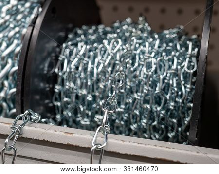 Roll Of Steel Chain Sitting In Indoors Storage Area Rolled Up To Be Spooled