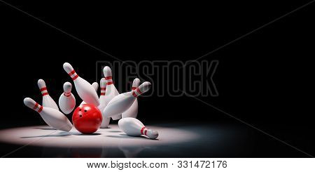 Strike Of Red And White Bowling Skittles With Red Ball Spotlighted On Black Background With Copy Spa