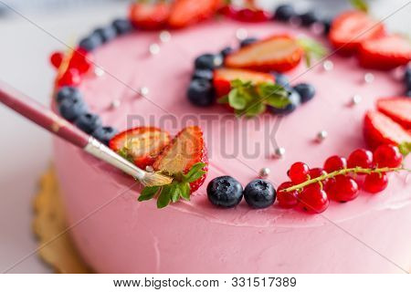 The Confectioner Decorating With Brush The Cake. Girl Birthday Cream Cheese Pink Cake. Golden Berrie