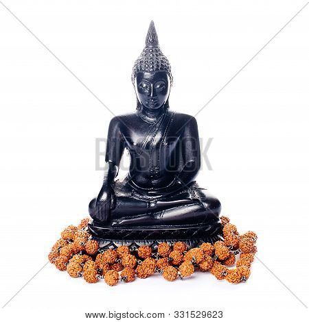 Closeup Of A Black Buddha Statue And A Japamala On A White Background