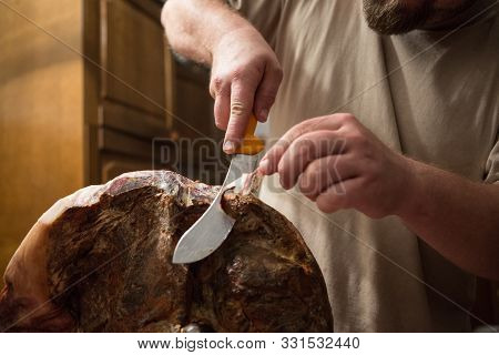 Home Cutting Of Home Made Prosciutto: A Man With The Knife